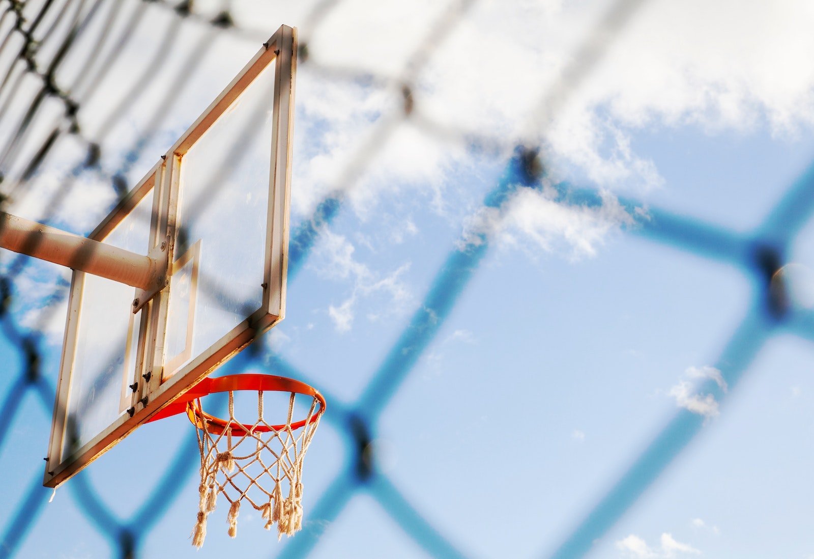 which hoop is higher netball or basketball? Low-Angle Photo of Basketball Hoop Under Blue Sky