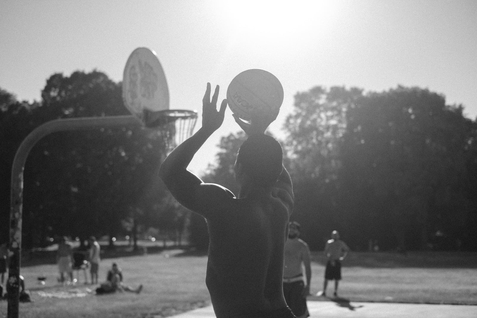 shooting hoops, is it harder to shoot in netball or basketball? grayscale photo of man playing basketball