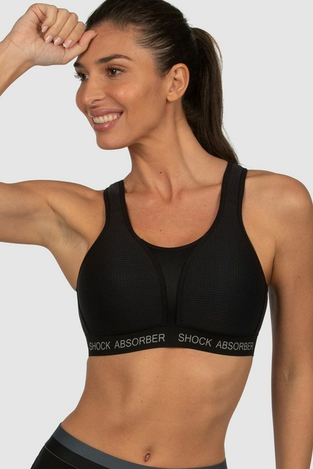 Shock absorber ultimate run bra in black - image girl flexing in bra